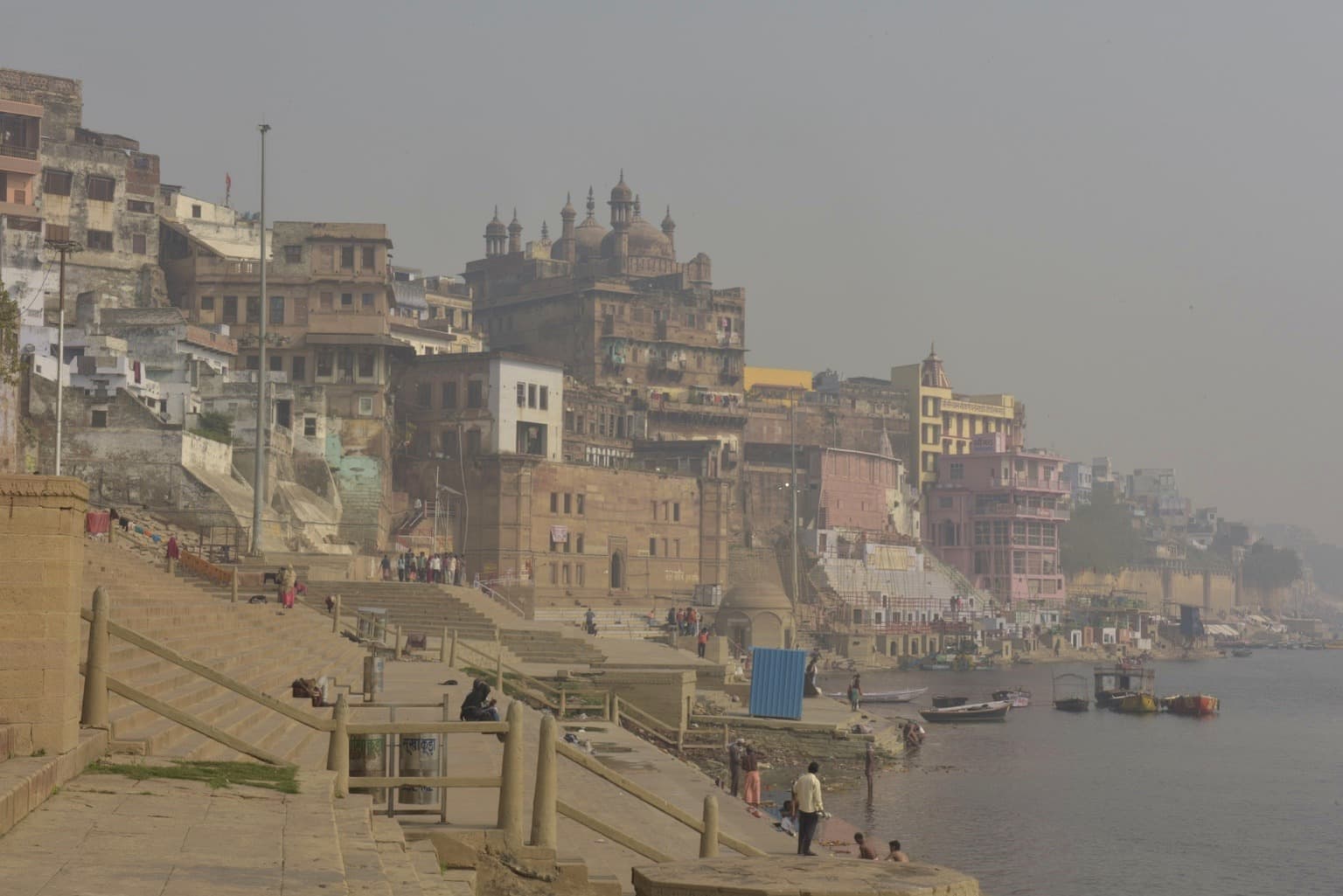 A hazy view of riverfront buildings and ghats along the Ganges in Varanasi, 2019