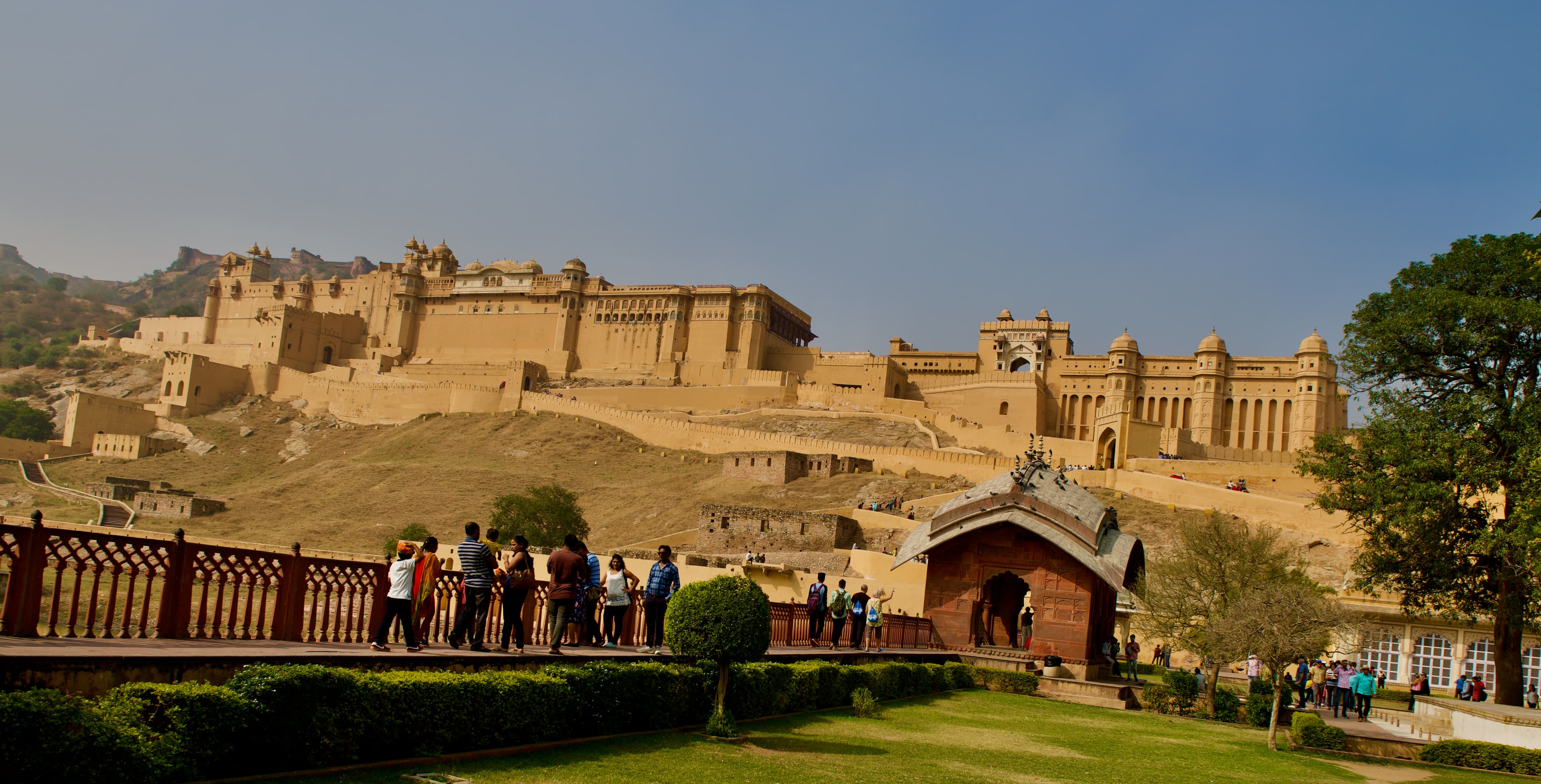 Visitors gather below the long walls and palace buildings of Amer Fort.