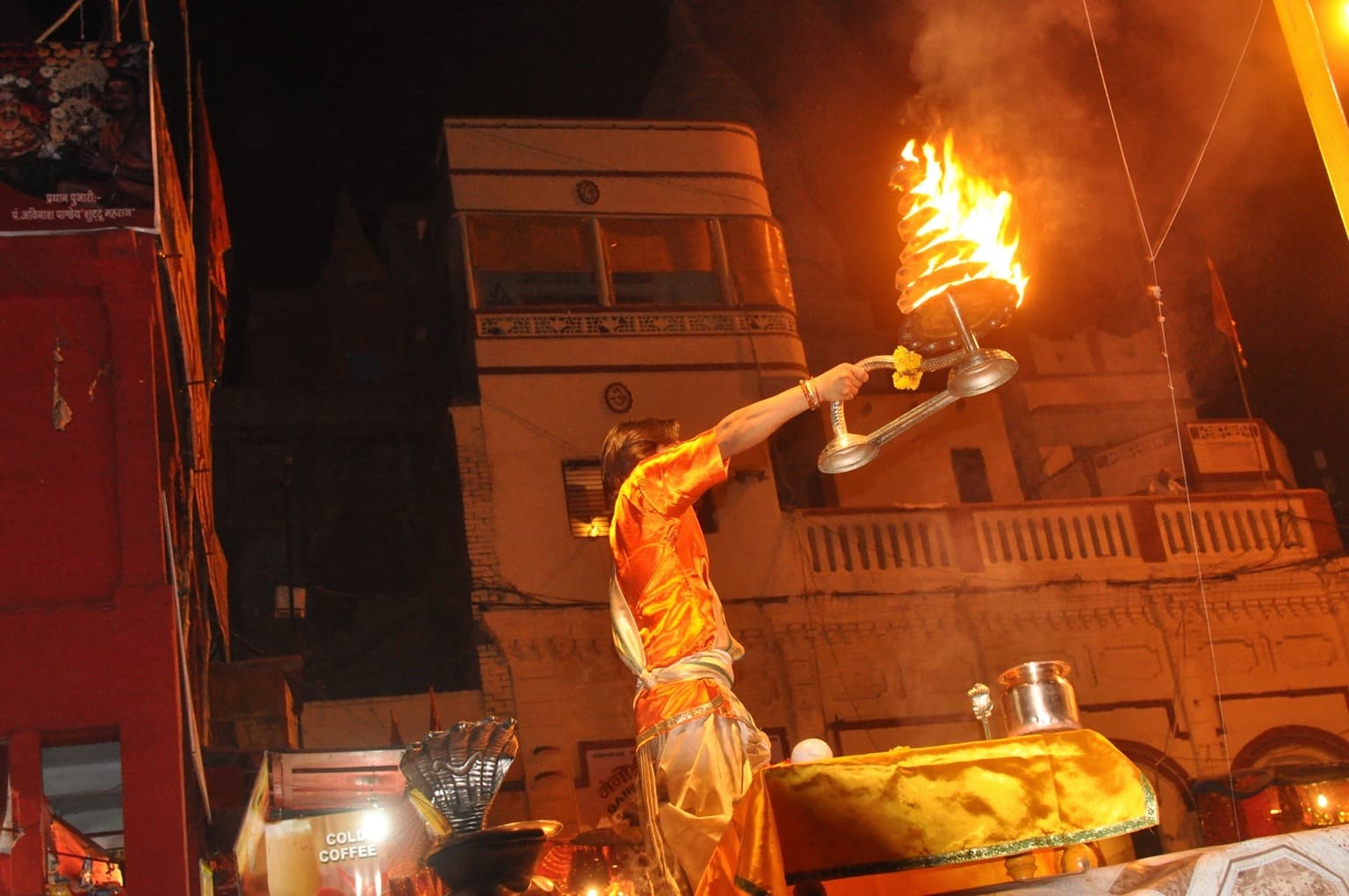 A priest raises a multi-tiered flaming lamp during evening aarti in Varanasi, photographed in 2014