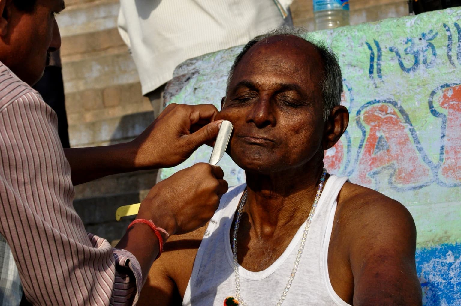 A close shaving scene on the ghats of Varanasi, photographed in 2014