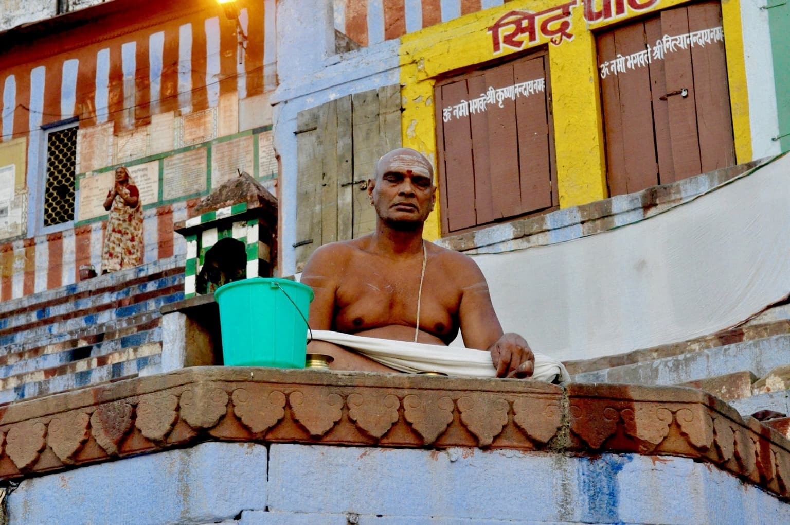 A meditating man seated on a platform on the ghats of Varanasi, photographed in 2014