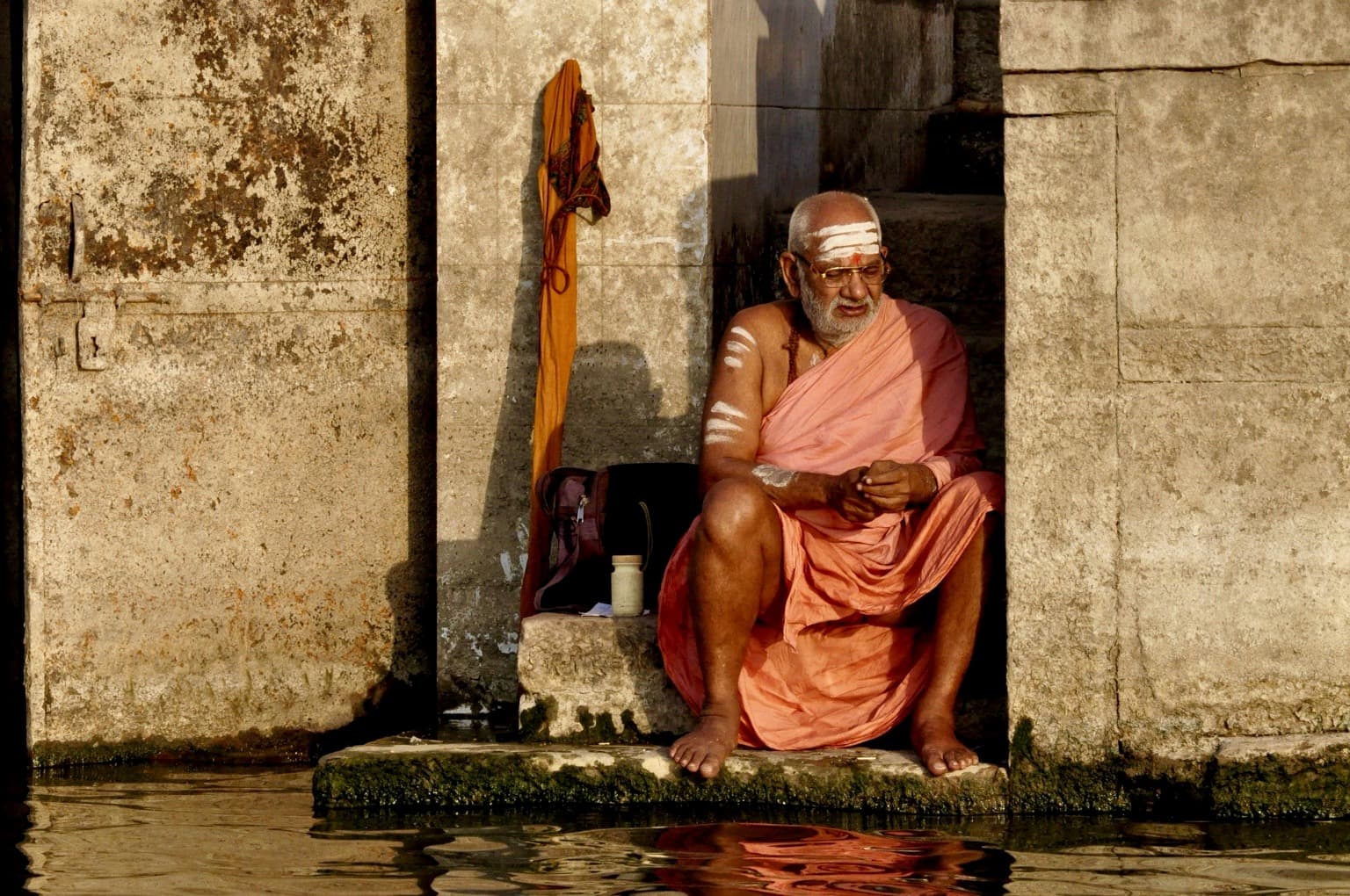 A seated holy man at the water’s edge in Varanasi, photographed in 2014