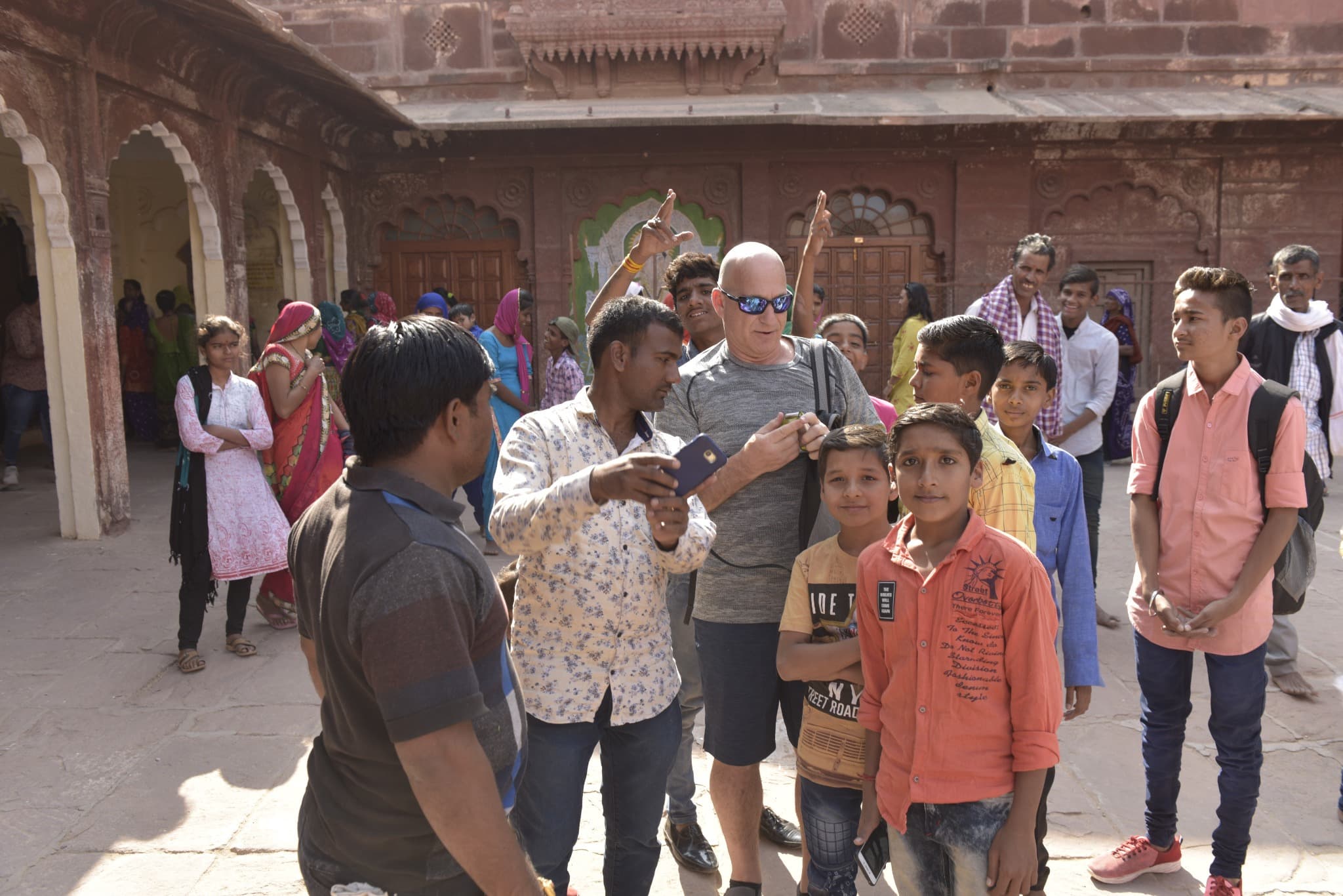 People gathering around Brian Silver as a man holds up a phone for a photograph.