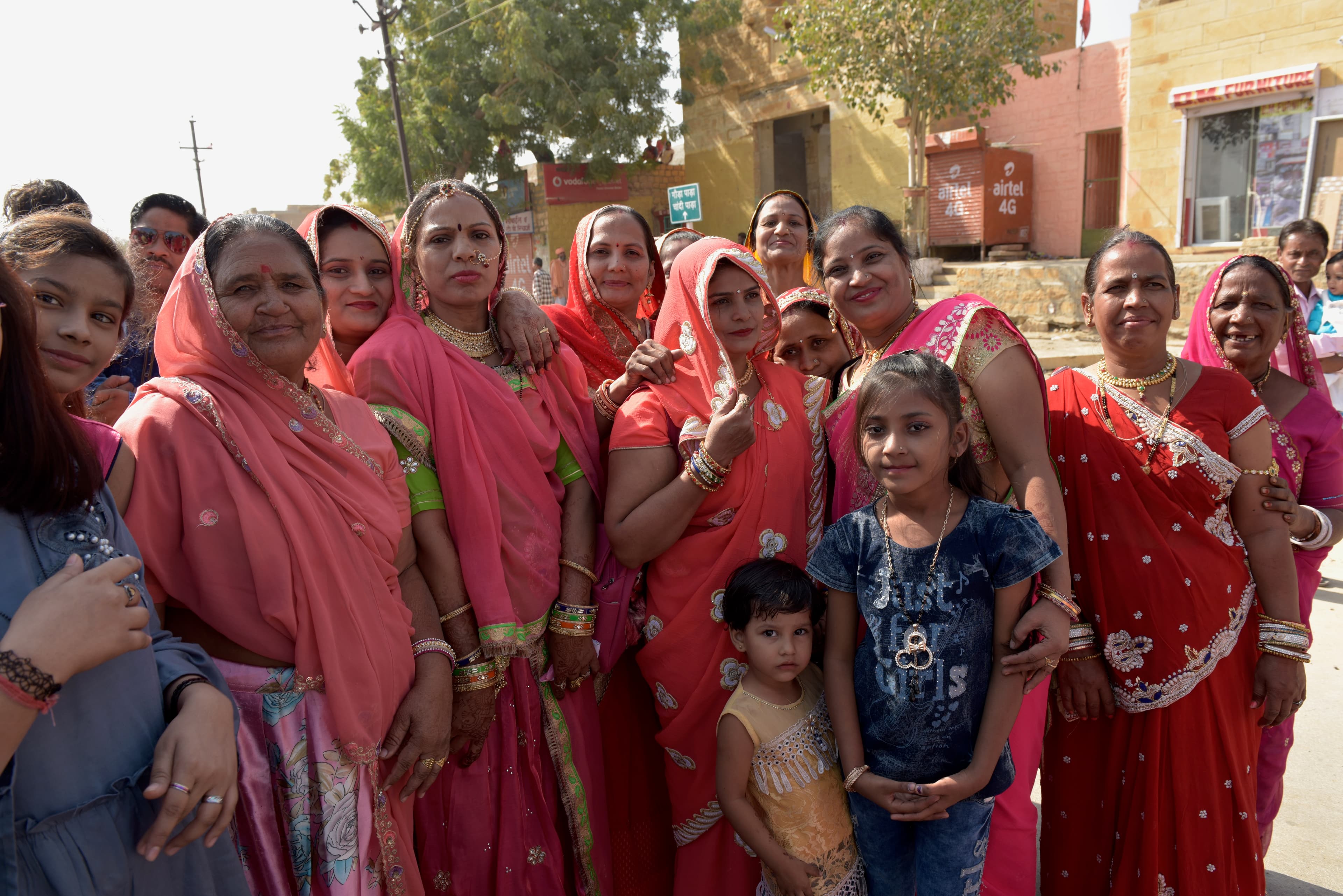 Women and children standing together for a photograph during the wedding procession.
