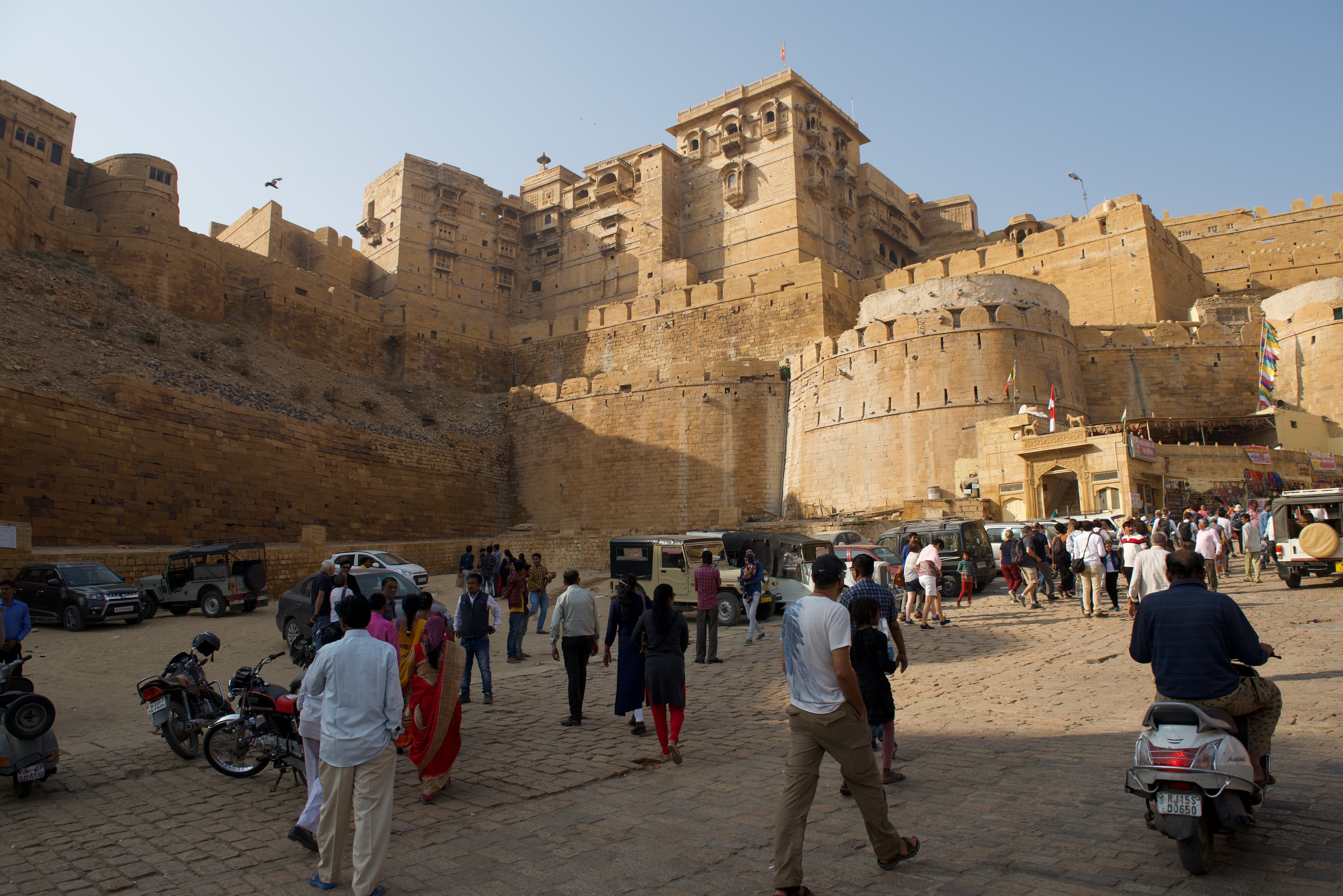 Pedestrians and traffic move through the sandstone entrance to Jaisalmer Fort.